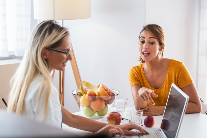 Professional nutritionist meeting a patient in the office. young smiling female nutritionist in the consultation room. Nutritionist desk with healthy fruit and measuring tape. Professional nutritionist meeting a patient in the office. young smiling female nutritionist in the consultation room. Nutritionist desk with healthy fruit and measuring tape.